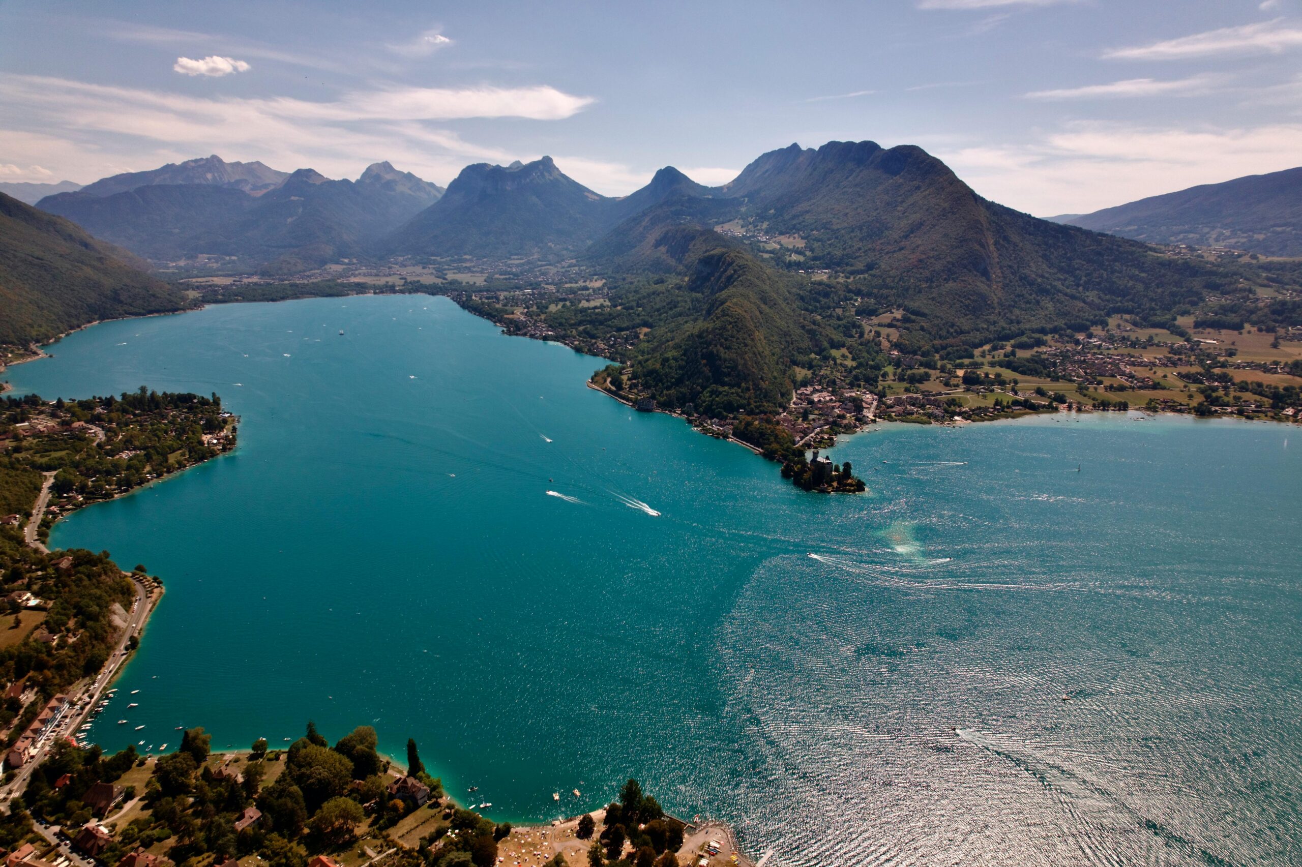 A breathtaking aerial photograph of Lake Annecy with surrounding mountains in Auvergne-Rhône-Alpes, France.