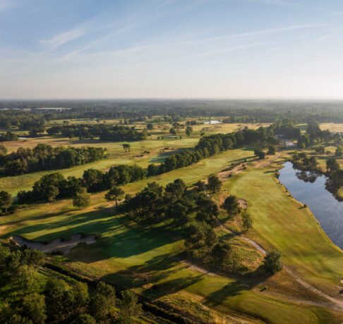 Aerial view of a premier French golf course highlighting its layout and surrounding landscape.