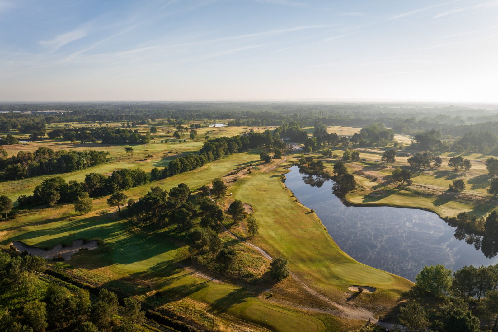 Aerial view of a premier French golf course highlighting its layout and surrounding landscape.